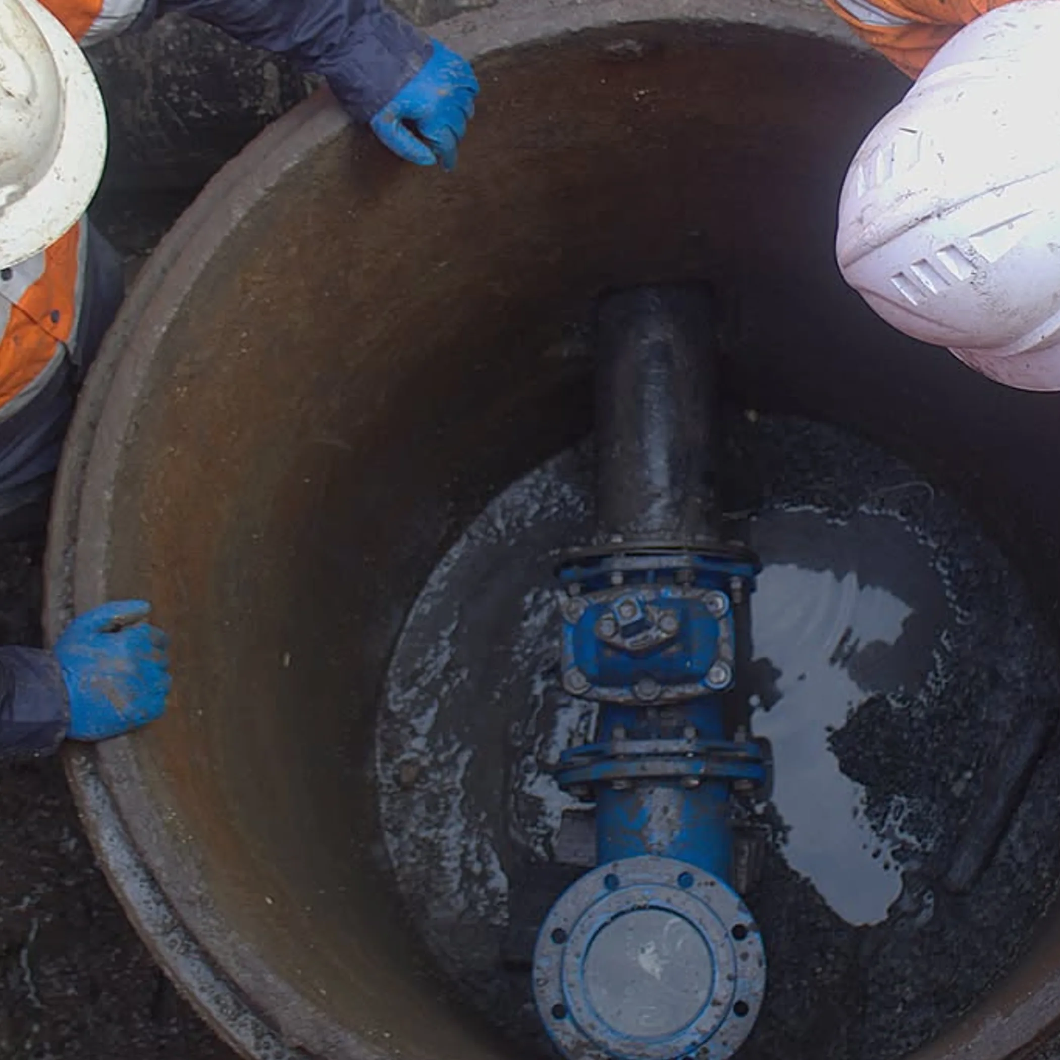 worker cleaning outdoor drain grate